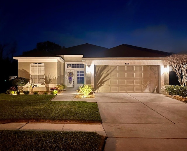 view of front of home featuring a garage and a yard