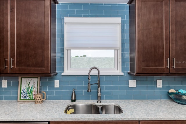 kitchen featuring light countertops, backsplash, and a sink