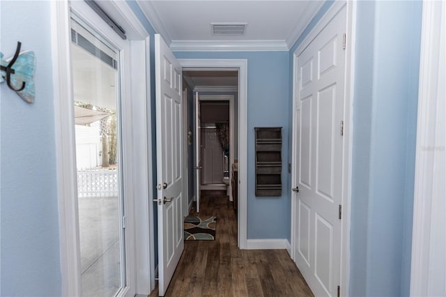 hall with ornamental molding, visible vents, baseboards, and dark wood-style floors