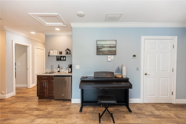 interior space with light wood finished floors, ornamental molding, visible vents, and baseboards