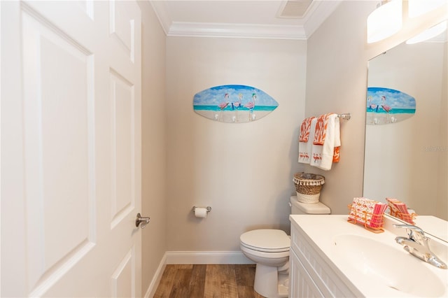 half bath with crown molding, visible vents, toilet, wood finished floors, and baseboards