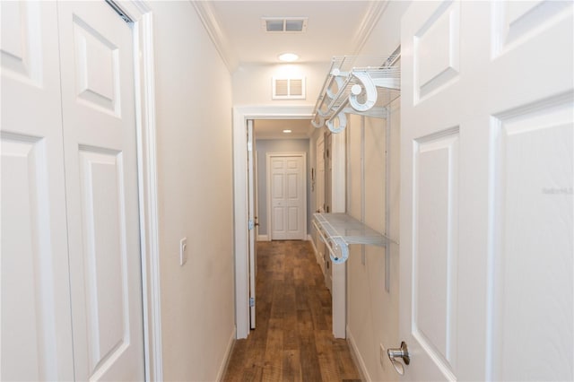 corridor featuring dark wood finished floors, visible vents, and crown molding