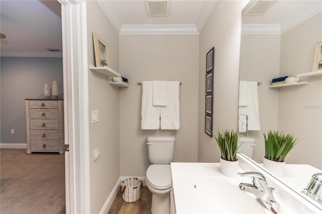 half bathroom with toilet, baseboards, visible vents, and crown molding