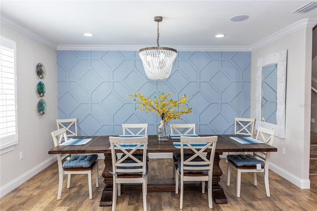 435 Jessamine Ave, New Smyrna Beach, FL 32169 - dining area with baseboards, an accent wall, ornamental molding, a chandelier, and recessed lighting
