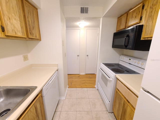 4034 Dream Oak Pl Unit 104, Tampa, FL 33613 - kitchen with light tile patterned floors, white appliances, sink, and a textured ceiling