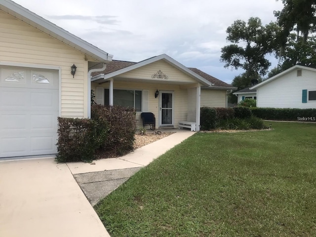 doorway to property with a garage and a yard