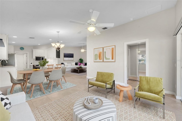 living area with visible vents, baseboards, recessed lighting, ceiling fan with notable chandelier, and light tile patterned flooring