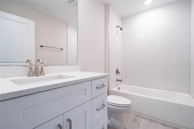 full bathroom with vanity, toilet, tiled shower / bath combo, and wood-type flooring