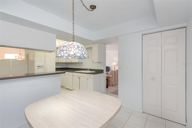 kitchen with sink, white cabinetry, decorative light fixtures, light tile patterned floors, and white appliances