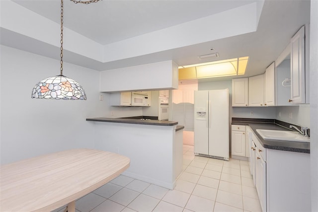 kitchen with light tile patterned floors, sink, white appliances, white cabinets, and kitchen peninsula