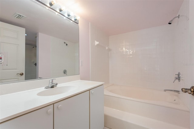 bathroom with vanity and tiled shower / bath