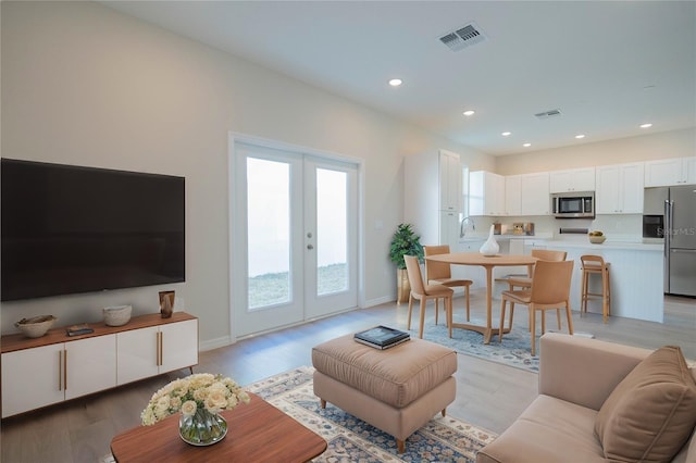 living room featuring light wood-type flooring and french doors