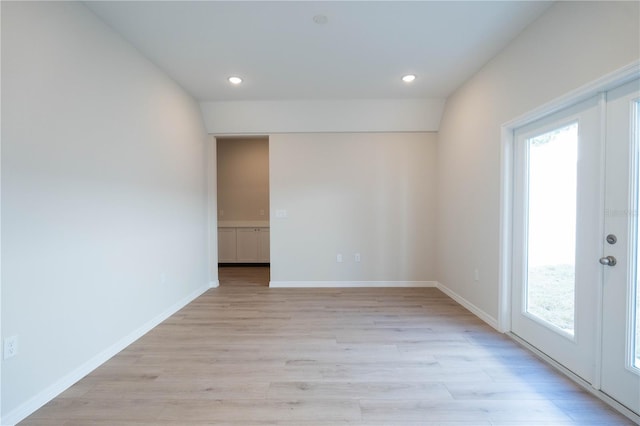 spare room with light hardwood / wood-style floors and french doors