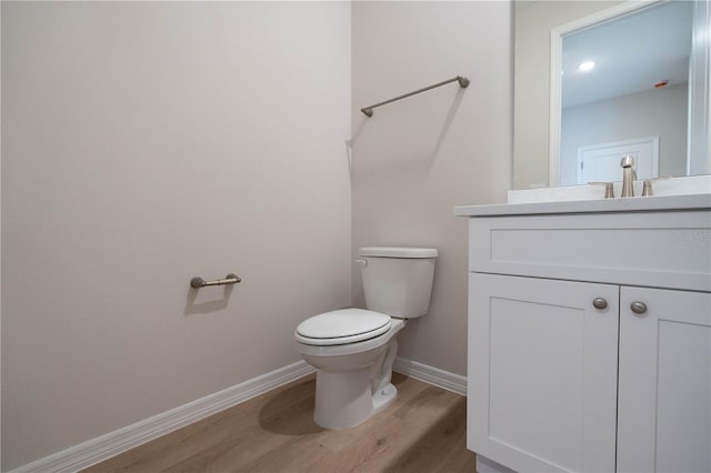 bathroom with vanity, wood-type flooring, and toilet