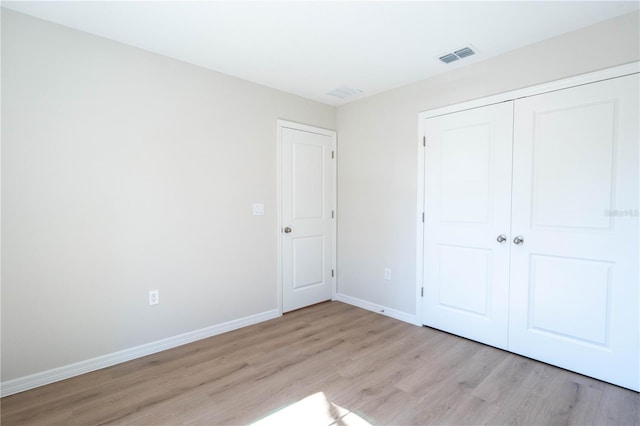 unfurnished bedroom with light hardwood / wood-style floors and a closet