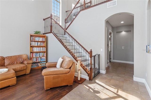 living room with hardwood / wood-style flooring and a towering ceiling