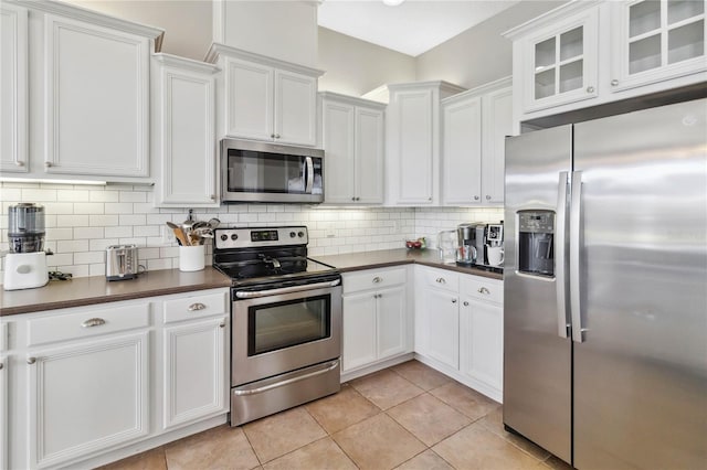 kitchen featuring stainless steel appliances, white cabinets, and decorative backsplash