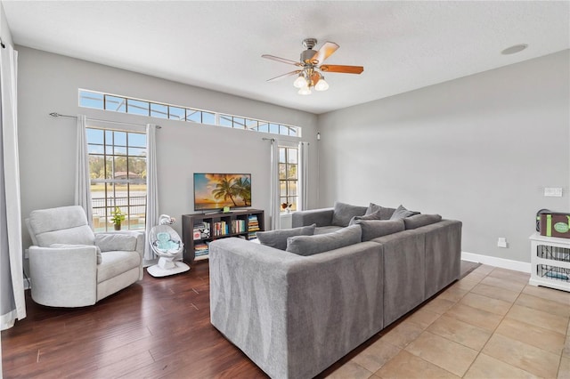 living room with hardwood / wood-style flooring, ceiling fan, and a textured ceiling