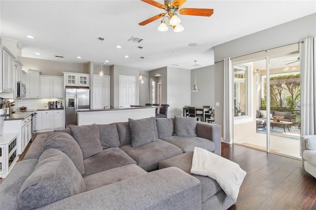 living room with dark hardwood / wood-style floors and ceiling fan