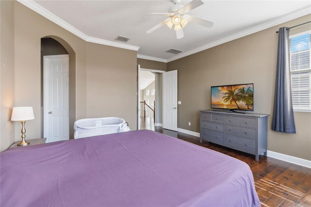 bedroom featuring dark wood-type flooring, ceiling fan, ornamental molding, and a textured ceiling