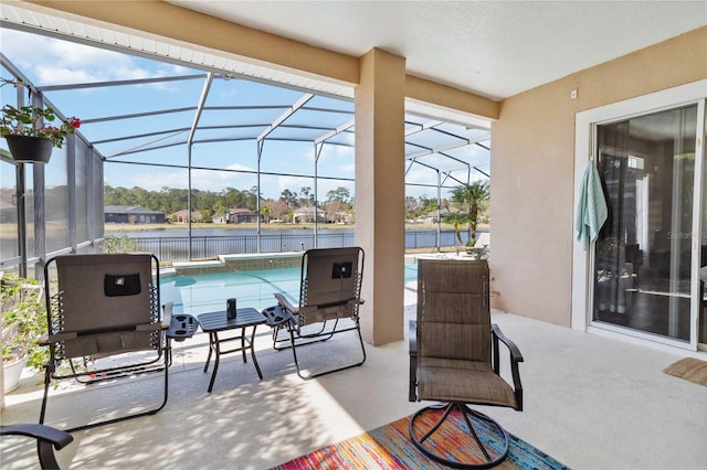 view of patio / terrace with a water view and glass enclosure