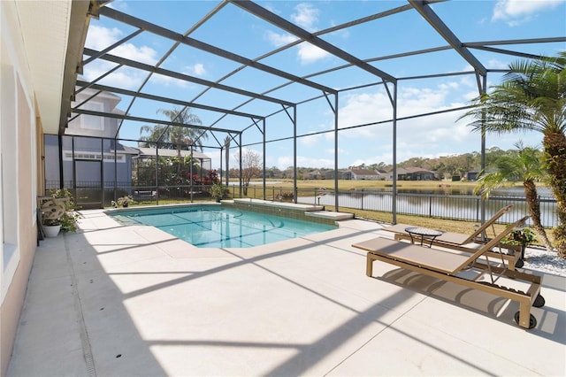 view of pool with a water view, glass enclosure, and a patio area