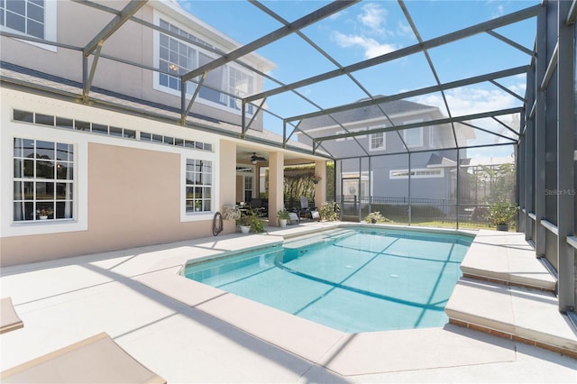 view of pool with ceiling fan, a lanai, and a patio area