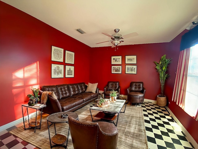 living area with tile patterned floors, visible vents, ceiling fan, and baseboards