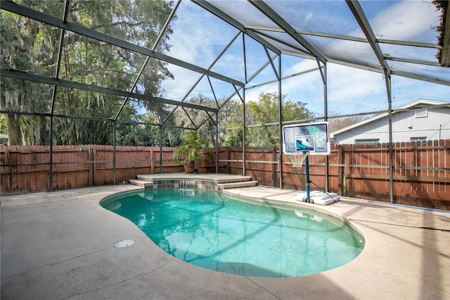 view of swimming pool with pool water feature, a patio area, and glass enclosure