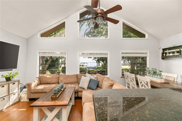 living room with hardwood / wood-style floors, high vaulted ceiling, and ceiling fan