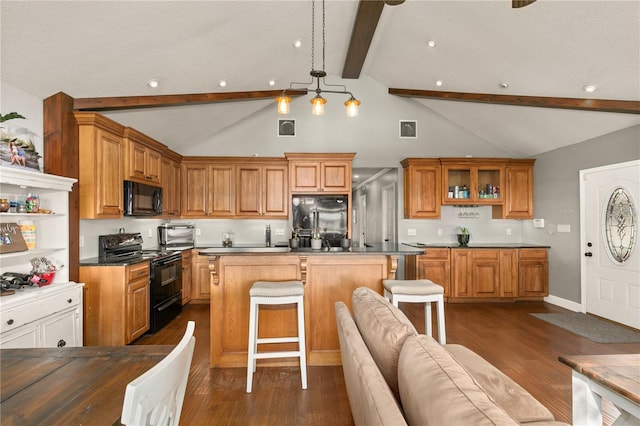 kitchen featuring a breakfast bar, decorative light fixtures, a center island, dark hardwood / wood-style flooring, and black appliances