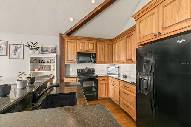 kitchen featuring sink, lofted ceiling with beams, light hardwood / wood-style flooring, dark stone countertops, and black appliances