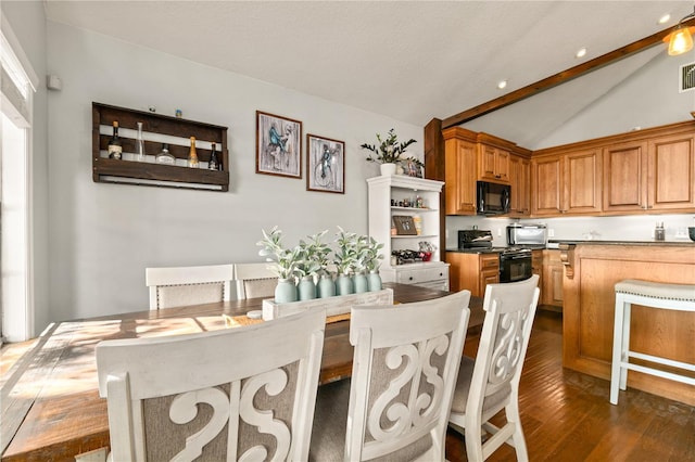 dining space featuring dark hardwood / wood-style flooring and lofted ceiling with beams