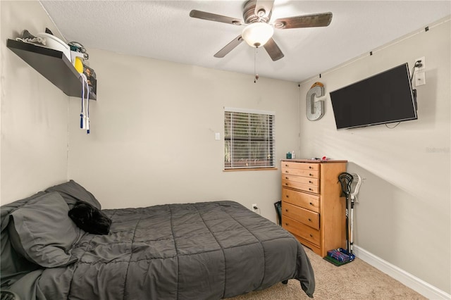 carpeted bedroom with ceiling fan and a textured ceiling