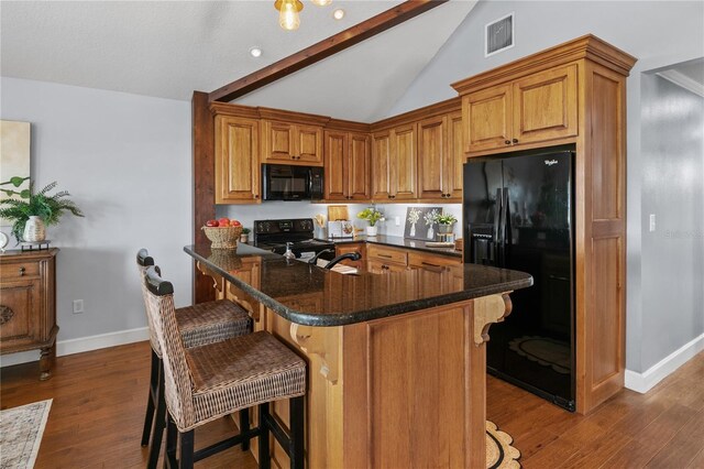 2929 Lakeshore Dr, Mount Dora, FL 32757 - kitchen with black appliances, a kitchen breakfast bar, lofted ceiling, dark wood-style flooring, and baseboards