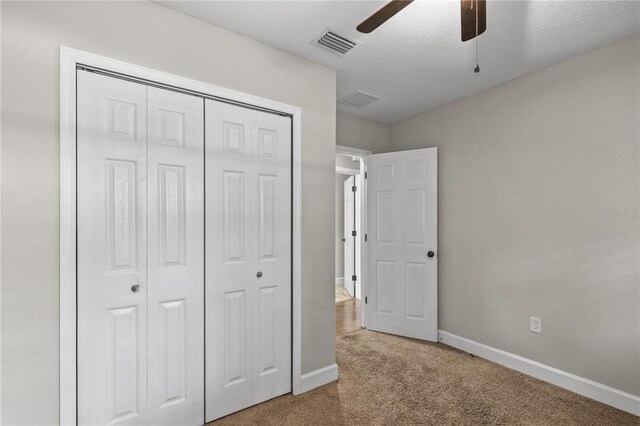 2929 Lakeshore Dr, Mount Dora, FL 32757 - unfurnished bedroom featuring carpet, a closet, baseboards, ceiling fan, and a textured ceiling