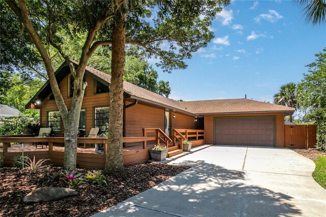 2929 Lakeshore Dr, Mount Dora, FL 32757 - view of front of property featuring concrete driveway, an attached garage, a wooden deck, roof with shingles, and a gate