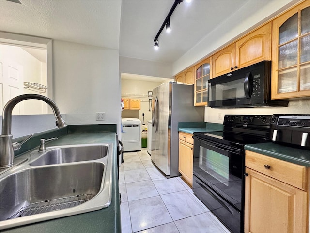 kitchen with light tile patterned flooring, washer / dryer, sink, black appliances, and a textured ceiling