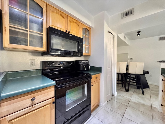 kitchen featuring light tile patterned flooring and black appliances