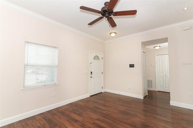 empty room with ornamental molding, wood finished floors, and visible vents