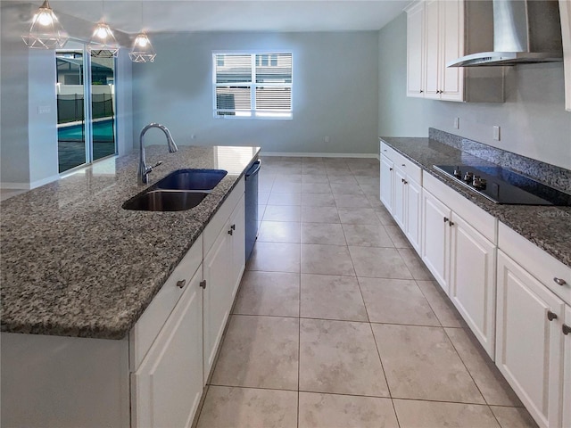 kitchen featuring sink, hanging light fixtures, black electric stovetop, a kitchen island with sink, and wall chimney range hood