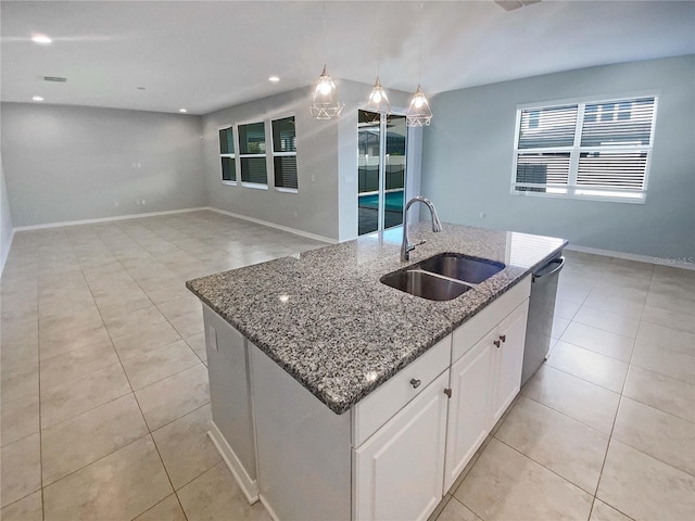 kitchen featuring sink, a kitchen island with sink, white cabinets, decorative light fixtures, and stainless steel dishwasher