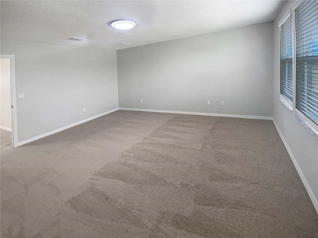 spare room featuring carpet floors and a textured ceiling