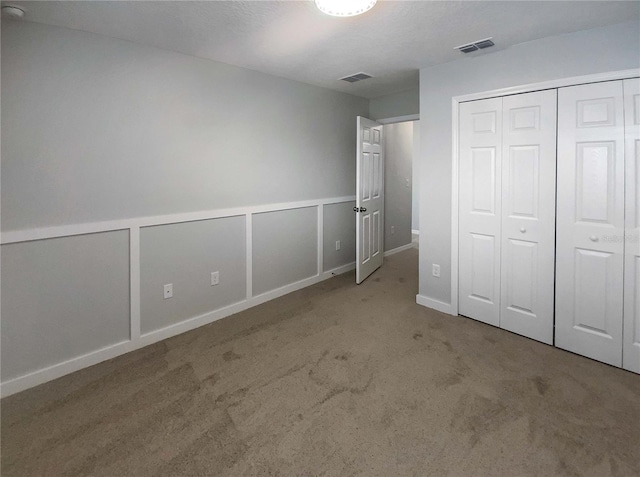 unfurnished bedroom featuring carpet floors and a closet