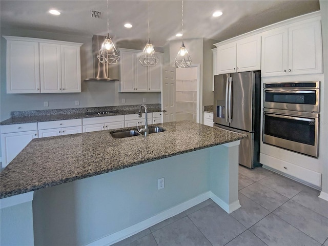 kitchen featuring extractor fan, decorative light fixtures, white cabinetry, sink, and stainless steel appliances