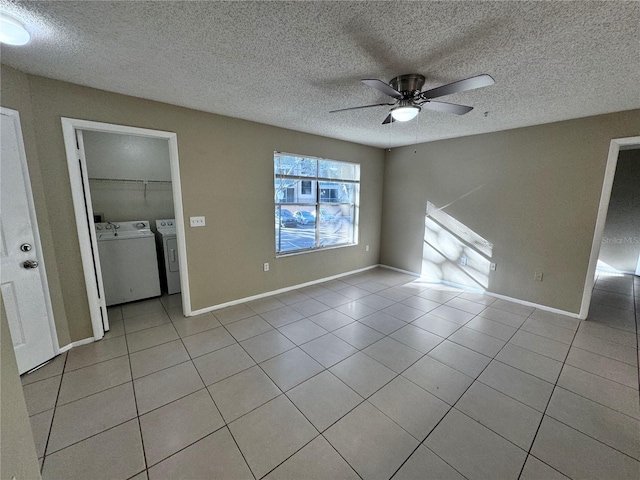 unfurnished room featuring ceiling fan, light tile patterned floors, a textured ceiling, and washer and clothes dryer