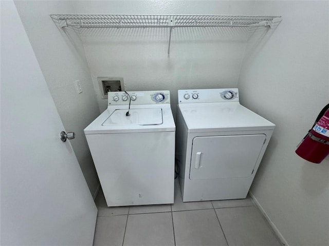 laundry room featuring washer and clothes dryer and light tile patterned flooring