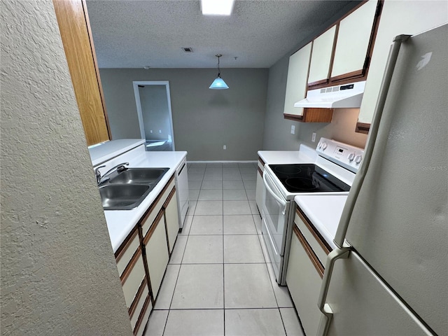 kitchen featuring decorative light fixtures, sink, white cabinets, fridge, and electric stove