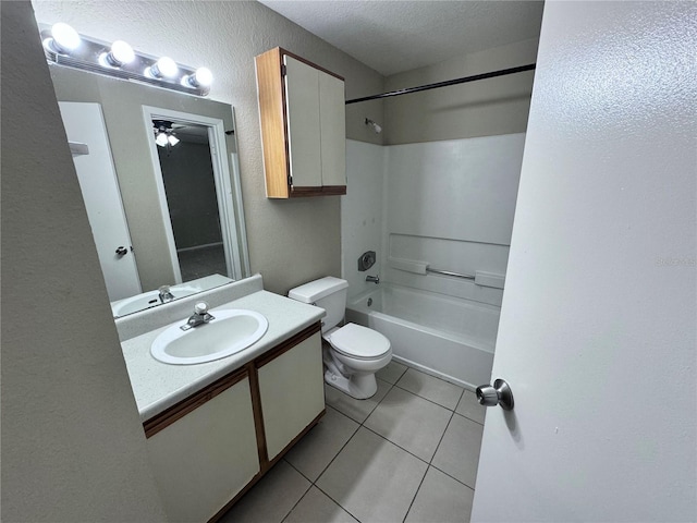 full bathroom featuring washtub / shower combination, tile patterned flooring, vanity, a textured ceiling, and toilet