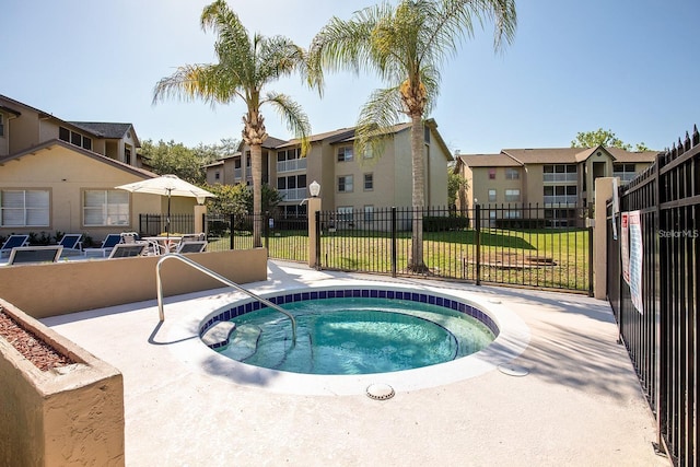 view of pool featuring a yard, a patio area, and a community hot tub